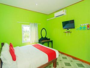 a green bedroom with a bed and a television at OYO 527 Tanfa Resort in Ban Nong Khang