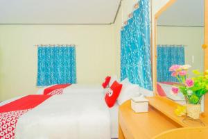 a bedroom with a bed and a desk with a mirror at OYO 527 Tanfa Resort in Ban Nong Khang +97 photos
