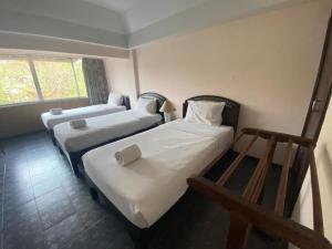 a room with two beds and a window at OYO 903 Madame Kim Hostel in Lampang