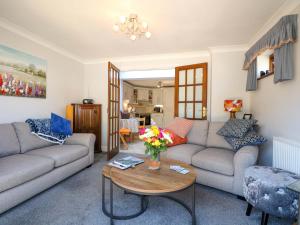 Una sala de estar con dos sofás y una mesa. en Lavender Cottage, en Hailsham