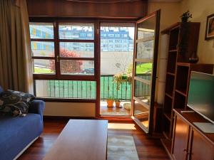 a living room with a couch and a large window at Apartamento completo a 7 minutos de la playa con parking in Castro-Urdiales