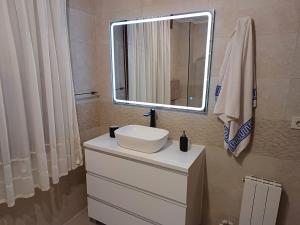 a bathroom with a sink and a mirror on a dresser at Apartamento completo a 7 minutos de la playa con parking in Castro-Urdiales +6 photos