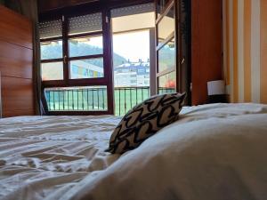 a bedroom with a large bed with a large window at Apartamento completo a 7 minutos de la playa con parking in Castro-Urdiales
