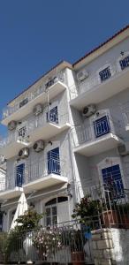 een hoog wit gebouw met blauwe balkons erop bij Hotel Antonios in Pythagoreio +8 foto's