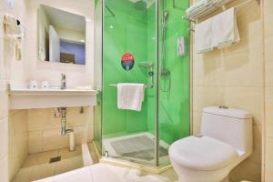 La salle de bains verte est pourvue de toilettes et d'une douche. dans l'établissement GreenTree Inn Beijing Tongzhou District Ciqu Subway Station Express Hotel, à Pékin
