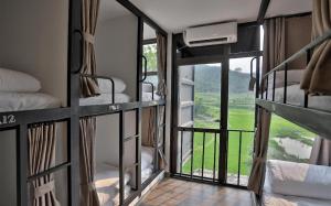 a room with bunk beds with a view of a field at Pu Luong Hostel in Ải Hạ
