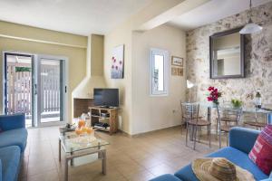 a living room with a blue couch and a table at Villa Arethusa by Villa Plus in Ratzaklíon