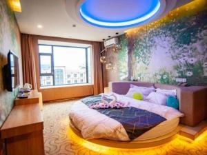 a bedroom with a large bed with a blue ceiling at Impression Li River Hotel (Guilin North Railway Station Branch) in Guilin