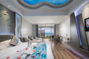a bedroom with a large bed and a living room at HuangMa holiday yacht view sea resort hotel in Haikou