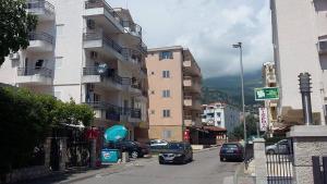 una calle de la ciudad con coches estacionados junto a edificios altos en Rossa Apartments, en Budva