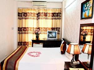 Un dormitorio con una cama y un televisor. en Kangaroo Hostel, en Hanói