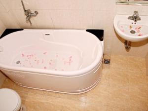 Una bañera en un baño al lado de un lavabo. en Kangaroo Hostel, en Hanói