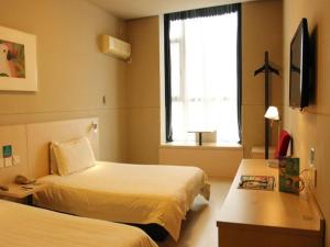 a hotel room with two beds and a window at Jinjiang Inn Tiayuan Wuyi Square in Taiyuan
