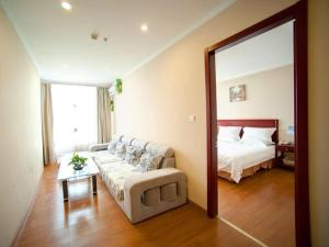 un salon avec un canapé, un lit et un miroir dans l'établissement GreenTree Inn Suzhou Exhibition Center Express Hotel, à Suzhou 19 autres photos