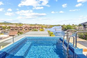 a pool with a view of a river and houses at Zodiac Penthouse - Sea & Mountain in Rivière Noire