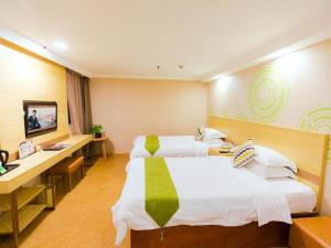 pokój hotelowy z dwoma łóżkami i biurkiem w obiekcie GreenTree Inn Shanghai Guangxin Road Tongji Hospital Express Hotel w Szanghaju