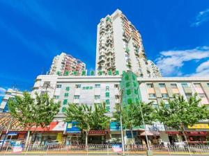 wysoki budynek z drzewami przed ulicą w obiekcie GreenTree Inn Shanghai Guangxin Road Tongji Hospital Express Hotel w Szanghaju