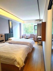 a hotel room with two beds and a desk at GreenTree Inn Langfang GuanGYAng District GuanGYAng Road City Government Express Hotel in Langfang