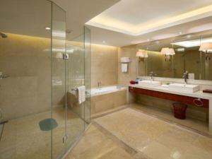 a bathroom with a shower and two sinks and a tub at Yiyang Huatian Hotel in Yiyang +202 photos