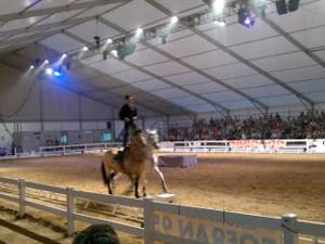 un hombre de pie sobre un caballo en una arena en Can Mestre, en Cambrils