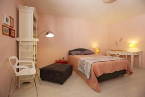 a bedroom with a bed and a chair and a table at Downtown Accommodation 2BR in Zadar
