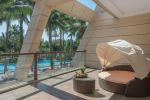 a balcony with a chair and a view of a pool at Jinsha Seaview Hotel Sanya in Sanya