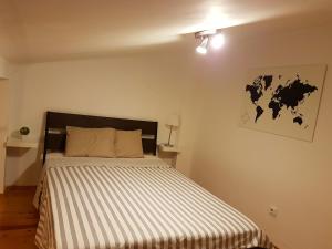 1 dormitorio con 1 cama con edredón a rayas en Pedaço de Lisboa, en Lisboa