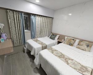 a hotel room with two beds and a window at New Star Guest House in Hong Kong