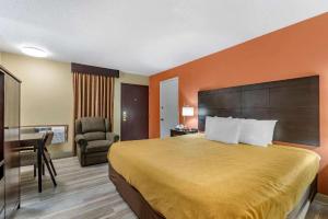 a hotel room with a bed and a desk at Econo Lodge Urbandale - Northwest Des Moines in Urbandale +64 photos
