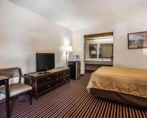 a hotel room with a bed and a flat screen tv at Econo Lodge Urbandale - Northwest Des Moines in Urbandale