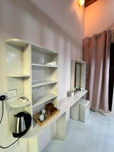 a kitchen with white shelves and a sink at Home In Dhigurah in Dhigurah