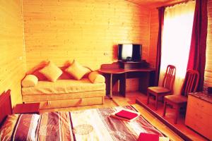 a living room with a couch and a table with a television at Садиба Леонтія in Skhidnitsa