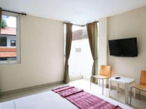 a living room with a tv and a window at Sanur Ayu Hotel in Sanur