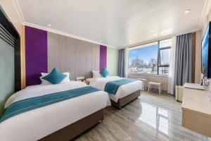 a hotel room with two beds and a window at JIN HENG HUA YAN HOTEL in Guangzhou