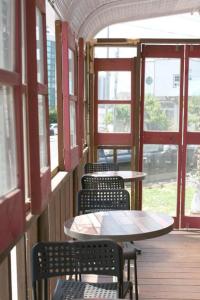 a row of tables and chairs in a building with windows at Capsule Inn Gangneung in Gangneung