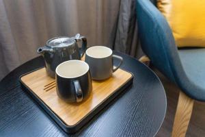 a tray with two coffee mugs on a table at Home Inn Selected Xiamen University Zhongshan Road in Xiamen