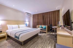 a hotel room with a bed and a desk at City Comfort Inn Liuzhou Diwang North Station in Liuzhou