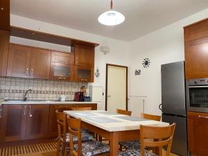 a kitchen with wooden cabinets and a table with chairs at B&B La Casa Mè in Francavilla al Mare