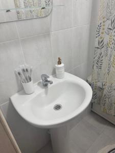 a white sink in a bathroom with a shower at 2-х комнатная квартира в районе Костанай плаза in Kostanay