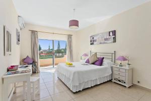 une chambre blanche avec un lit et un balcon dans l'établissement Villa Uma by Villa Plus, à Loulé 26 autres photos