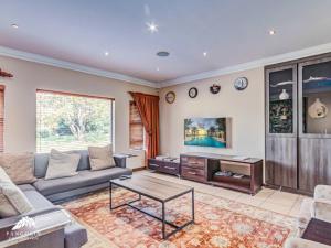 un soggiorno con un divano e un tavolo di Villa Vuso by Euphoric Leisure a Benoni