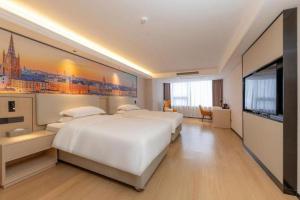 a hotel room with a large bed and a flat screen tv at Vienna International Hotel Guangzhou Huangpu in Guangzhou
