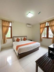 a bedroom with a bed and a bench in it at Ole Suite Hotel and Cottage in Bogor +100 photos