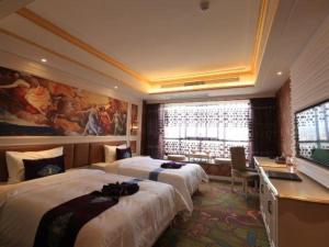 a hotel room with two beds and a desk at Yonghe Tianmen Boutique Hotel in Zhangjiajie
