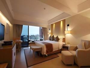 Cette grande chambre comprend un lit et une télévision. dans l'établissement Man Wan Harmona Resort, à Youcaopeng 253 autres photos