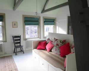 a living room with a couch with red pillows at Heer&Meester Bed&Breakfast in Dordrecht