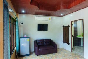 a living room with a couch and a television at Suvimon Resort in Si Maha Phot +52 photos