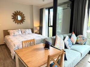 a bedroom with a bed and a table and a couch at Deck Condo private apartment by Lofty in Patong Beach +10 photos