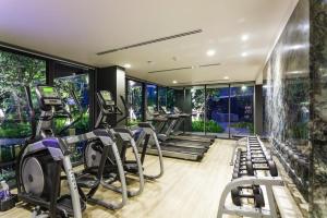 a gym with treadmills and elliptical machines at Deck Condo private apartment by Lofty in Patong Beach