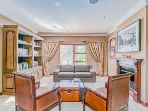 un soggiorno con un divano, un tavolo e delle sedie di Villa Vuso by Euphoric Leisure a Benoni